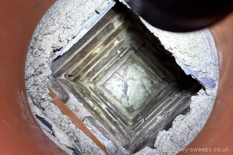 View down chimney pot showing blockage and decayed rendered lining — pre-purchase chimney inspection, NACS registered, Allchimney Sweeps, Rise Park, Romford