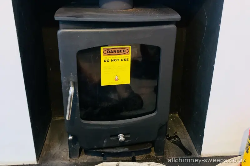 DANGER DO NOT USE warning notice affixed to wood burning stove during NACS chimney sweep inspection — carbon monoxide safety, Allchimney Sweeps, Upminster